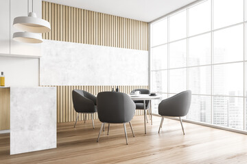 Four grey chairs around table in dining room in modern light wooden kitchen