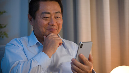 スマートフォンを使う中年男性