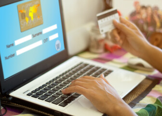 Woman hand holding credit card and filling in the information of personal data for online shopping at home. Online shopping concept.