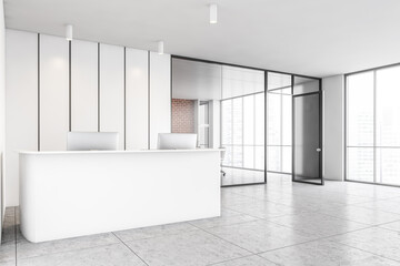 White office reception with laptops and glass conference room side view