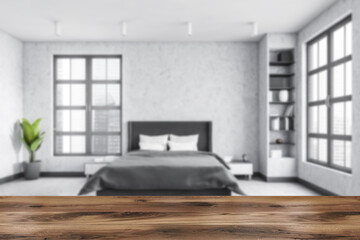 Grey bedroom with bed and linens, grey walls and window with a city view