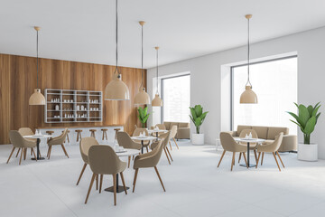 Cafe interior, many brown chairs and tables, wooden wall with lamps, dining room