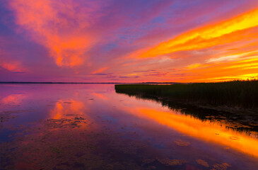 Beautiful colorful sunset over the lake summer landscape.