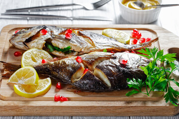 Whole baked dorado fish on a cutting board