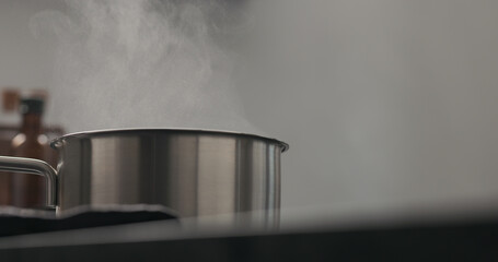 Slow motion steam rising from saucepan with copy space
