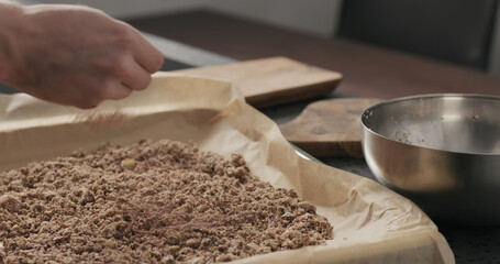 Slow motion making granola, spread on baking sheet