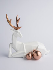 Creative Christmas layout made with white deer and rose gold bauble ornaments on bright background....