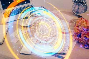 Computer on desktop in office with technology theme hologram. Double exposure. Tech concept.