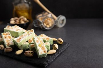 Fototapeta na wymiar Homemade pistachio nougat on a dark rustic background