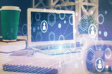 Computer on desktop with social network hologram. Multi exposure. Concept of international people connections.
