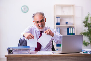 Old male employee working in the office