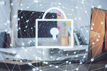Double exposure of desktop with computer and lock icon hologram. Concept of data safety.