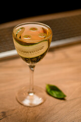 view of glass with drink and slice of cucumber standing on wooden surface