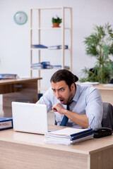 Young male bookkeeper working in the office