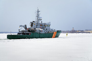 Helsinki, Finland. Border guard ship goes to Suomenlinna fortress in winter.