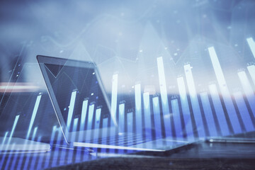 Naklejka premium Stock market chart hologram drawn on personal computer background. Double exposure. Concept of investment.