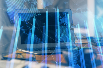 Stock market graph on background with desk and personal computer. Multi exposure. Concept of financial analysis.