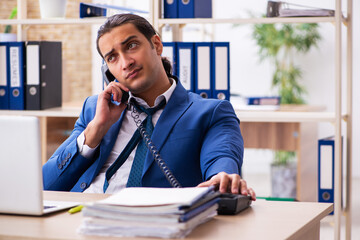 Young handsome employee sitting in the office