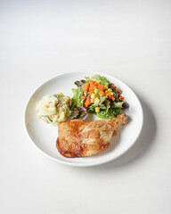 plate of delicious grilled chicken legs steak with vegetable and salad potato on white background