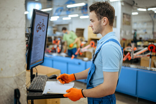 Bicycle factory, worker manages bike assembly line