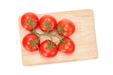 Top view of a fresh tomatoes bunch on a wooden cutting board.