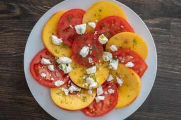 Colorful summer salad with tomatoes, nectarines and feta cheese , close up