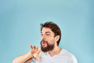 Emotional man with a beard in a white t-shirt blue background fun lifestyle