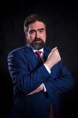 Mature businessman dressed in blue suit with red tie studio portrait.