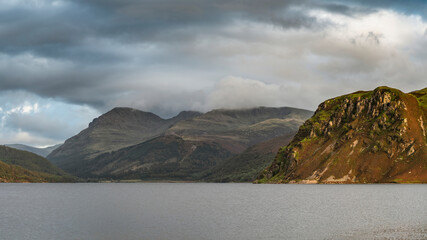 Stunning landscape image looking across Ennerdale Water in the English Lake District towards the peaks of Scoat Fell and Pillar during a glorious Summer sunset