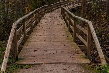 Obraz premium nature trail in autumn with wooden bridge