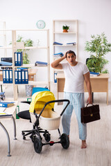 Young male employee looking after newborn at workplace