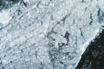Aerial Top-Down View of Cracked, Broken, and Melting Ice on a Water Surface.