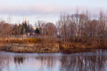 Northern view of the St. Charles River bank with church spires peeking behind woods and buildings in the background, Quebec City, Quebec, Canada