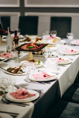 Festive table setting with snacks and flowers in the restaurant. Wedding table decor for guests