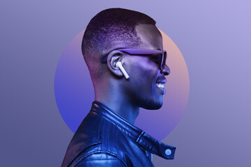 Portrait of smiling african american man listening music with earphones, wearing black leather...