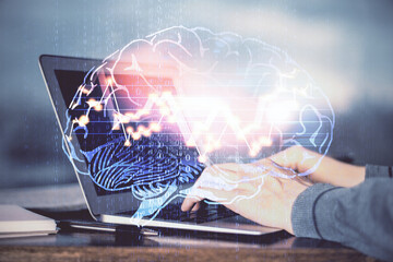 Man typing on keyboard background with brain hologram. Concept of big Data. Double exposure.