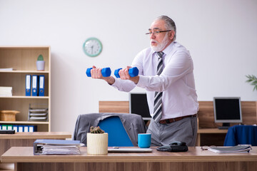 Old male employee suffering from radiculitis at workplace