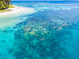 Aerial top down people snorkeling on coral reef tropical caribbean sea, turquoise blue water. Indonesia Banyak Islands Sumatra, tourist diving travel destination.