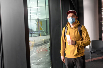 Naklejka premium A guy wearing medical mask in an airport