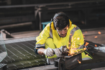 Man using angle grinder, worker uses protective equipment. Factory work