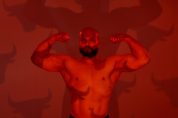 Silhouette of muscular caucasian bodybuilder showing biceps