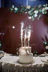beautiful wedding cake on a table with lights