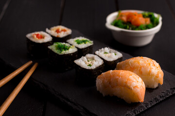 Sushi Set sashimi and sushi rolls on stone slate