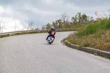Obraz premium two are riding a scooter motorcycle on the road to Crater of volcano Vesuvius, Italy Naples