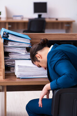 Young male employee unhappy with excessive work in the office