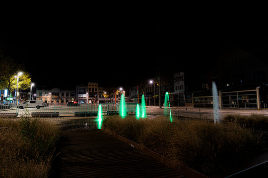 Nightshot of market place izegem with no people and all bars closed.  Enviremental shot of the market of the city combined with green fountains, all bars closed.  Overview of market of city izegem