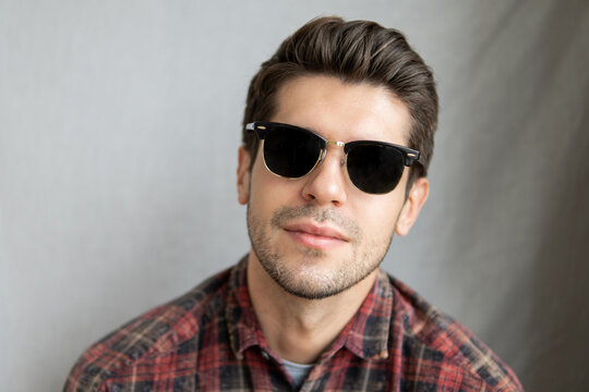 Portrait of a handsome latin man in black sunglasses with a serious face expression looking in to the camera 