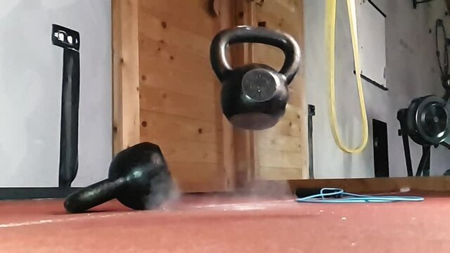 A kettlebell falling and bouncing back from a rubber floor. Superslowmotion