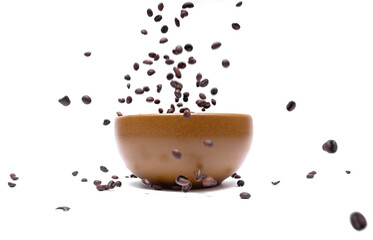 Flying coffee beans into a brown bowl on a white background, close-up. Blurred