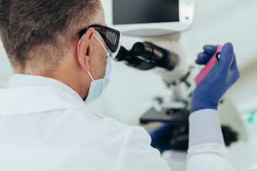 close up. scientist in a protective mask testing control samples.